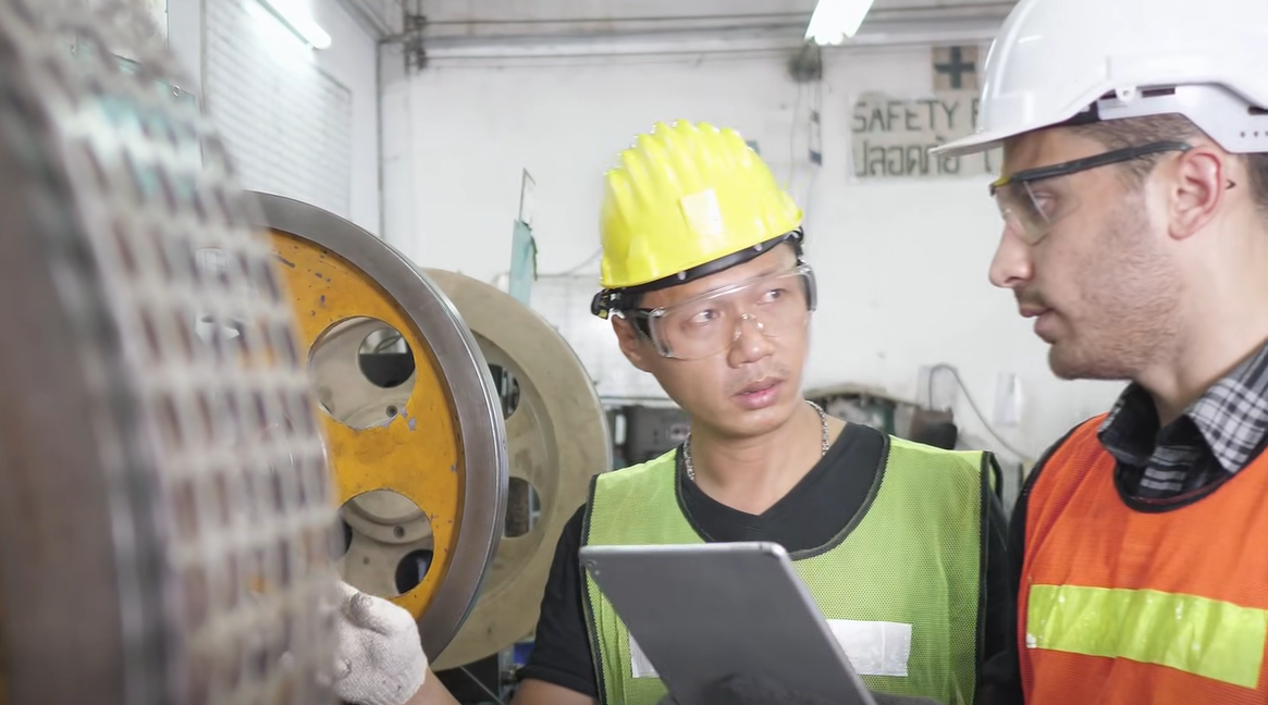 Kỹ thuật viên đang trao đổi trực tiếp quy trình vận hành thiết bị cùng chuyên gia nước ngoài tại xưởng sản xuất.