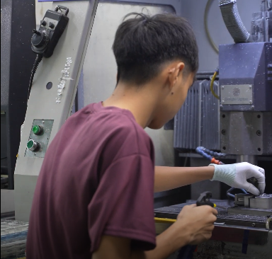 Kỹ thuật vi&ecirc;n cơ kh&iacute; đang thao t&aacute;c c&agrave;i đặt th&ocirc;ng số gia c&ocirc;ng tr&ecirc;n m&aacute;y CNC hiện đại.